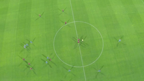 joueurs de football jouent au football dans un grand stade. uniformes rouges et bleus - Séquence, vidéo