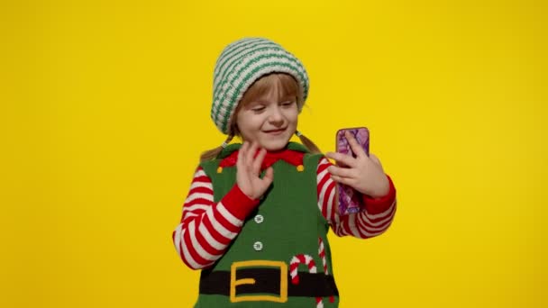 Kindermädchen im Weihnachtselfen-Helferkostüm macht Videoanruf auf Handy - Filmmaterial, Video