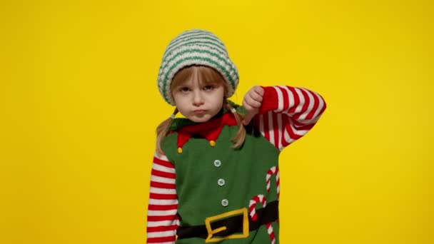 Знедолена дівчинка в костюмі різдвяного ельфа Санта помічника тримає великий палець вниз і показує нелюбовний жест
 - Кадри, відео