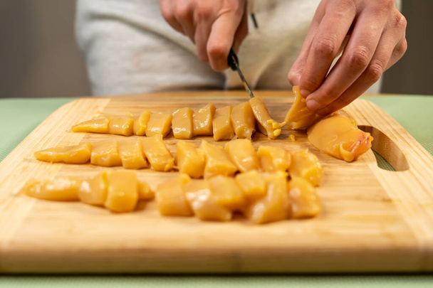 A closeup shot of a chef cutting gourmet free-range chicken breast - Fotó, kép