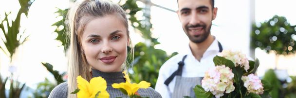 Flower shop owners holding beautiful flowering houseplants - Valokuva, kuva