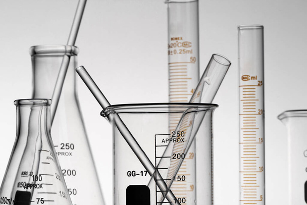 Eine Nahaufnahme von transparenten Laborkolben, Bechern und Röhrchen - Foto, Bild