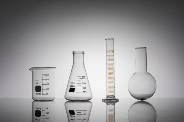 A closeup shot of laboratory flasks, beaker, and tube - Фото, изображение