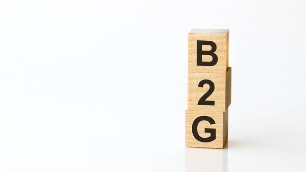 B2G -文字、ビジネスから政府への木製のブロックからの頭字語。白地. - 写真・画像