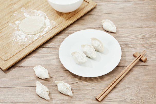 A top view shot of the uncooked dumplings on a wooden table - 写真・画像
