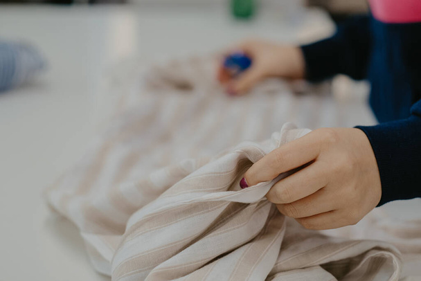 A shallow focus closeup of female hands holding a piece of white cloth - Φωτογραφία, εικόνα
