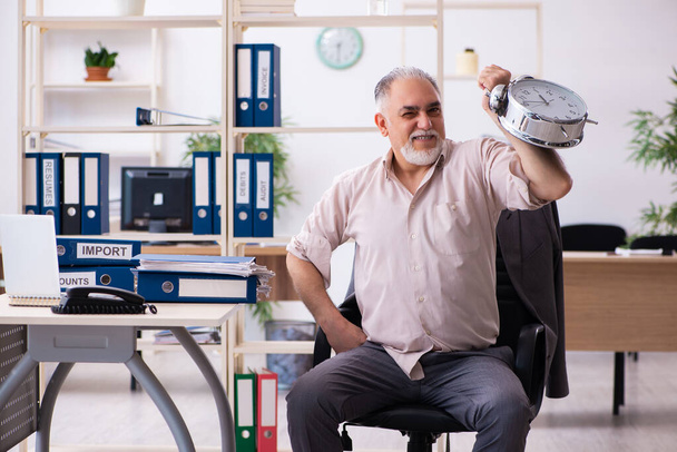 Viejo empleado masculino haciendo ejercicios físicos en la gestión del tiempo co - Foto, Imagen