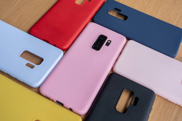 A high angle shot of colorful phone cases on a wooden table - Photo, Image
