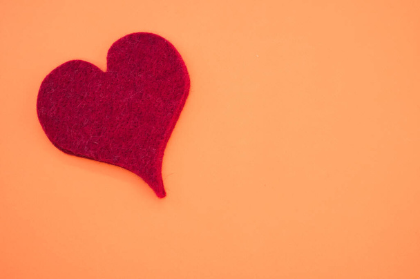 A top view of a red heart on orange background for a copy space - Fotoğraf, Görsel