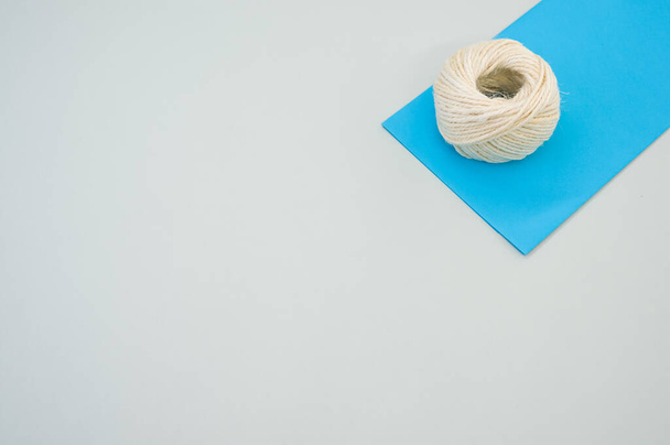 A closeup shot of white cord rope on a piece of paper on gray background - Foto, immagini