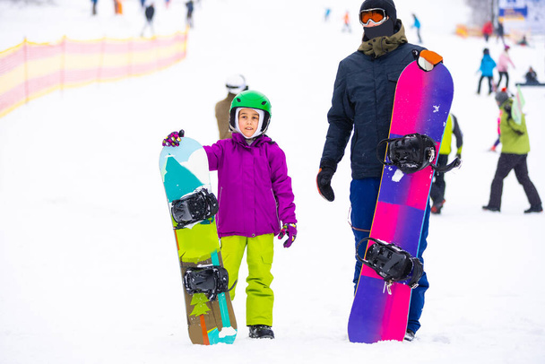 Instruktorzy uczą dziecko na śniegu na snowboardzie - Zdjęcie, obraz