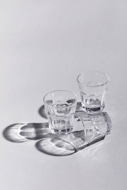 A vertical composition of glasses arrangement with shadows on white background - Fotó, kép