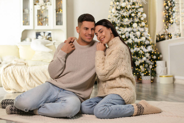 Happy couple on floor in room with Christmas tree - Foto, Bild
