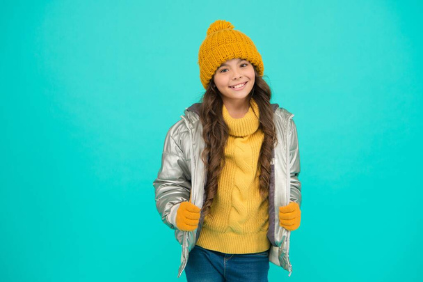 smiling teenage girl in padded or puffer jacket ready to spent winter holiday and vacation in comfort and warmth, knitted fashion - Fotoğraf, Görsel