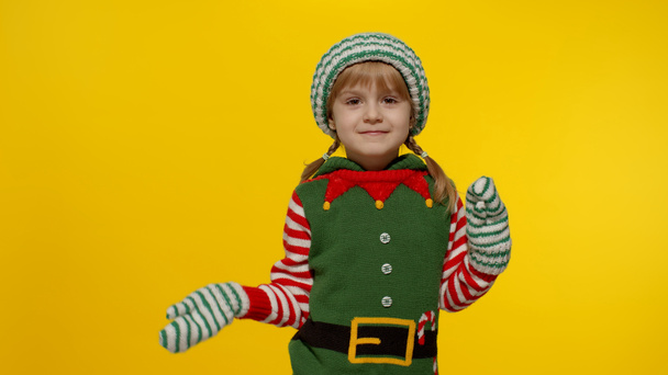 Kid girl in Christmas elf Santa helper costume dancing, fooling around. New Year holiday celebration - Photo, image