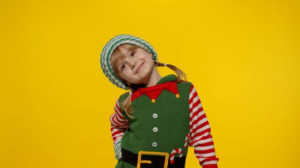 Kind meisje in kerst elf Kerstman helper kostuum glimlachen, rotzooien rond. Nieuwjaarsviering - Foto, afbeelding