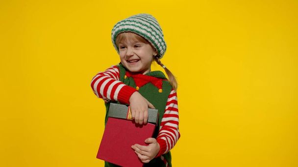 Kid girl in Christmas elf Santa helper costume getting, receiving present gift box. New Year holiday - Foto, imagen