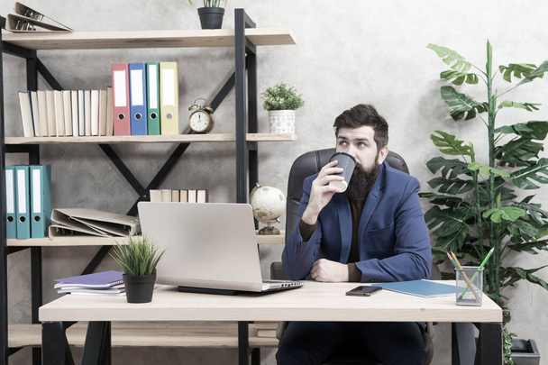 Sleepy half-awake bearded hipster in formalwear drink takeaway coffee in workplace, caffeine - Zdjęcie, obraz