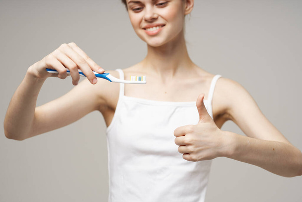 mujer sosteniendo un cepillo de dientes con pasta en las manos higiene dental de cerca - Foto, Imagen