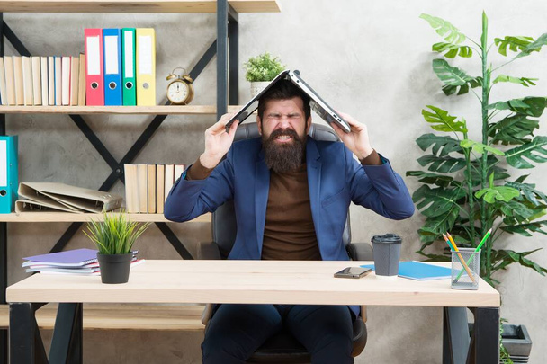 Always stressed. Crazy director hold laptop on head. Bearded man screaming in pain. Headache attack. Got stressed at work. Business stress management. Running business is stressful - Foto, imagen