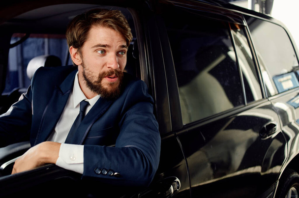 business man in suit driving car in showroom and emotions model - Foto, Bild
