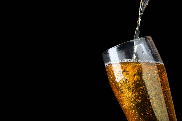 Pouring cold tasty beer into glass on black background, closeup. Space for text - Foto, imagen