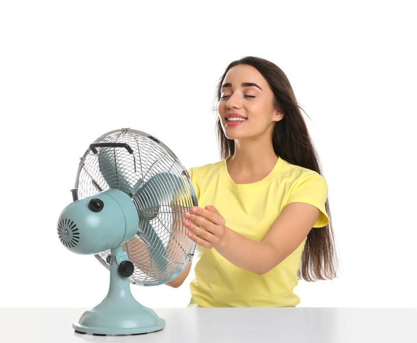 Woman enjoying air flow from fan on white background. Summer heat - Photo, image