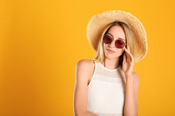 Beautiful woman in stylish sunglasses on yellow background. Space for text - Photo, Image