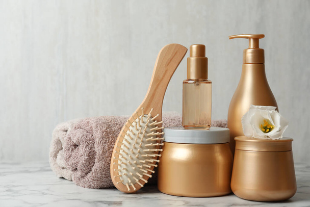 Different hair products, towel and brush on white marble table - 写真・画像