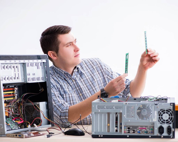 Молодий технік ремонтує комп'ютер в майстерні
 - Фото, зображення