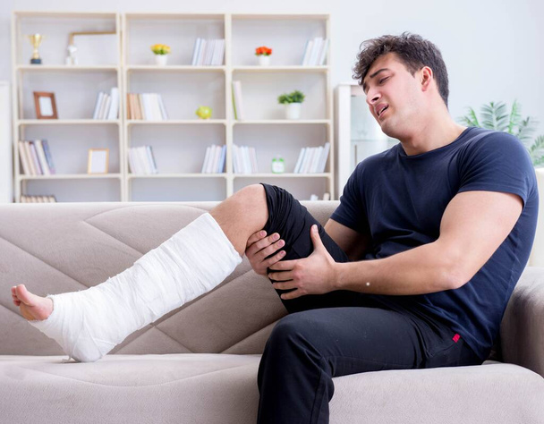Man with broken leg recovering at home - Фото, изображение