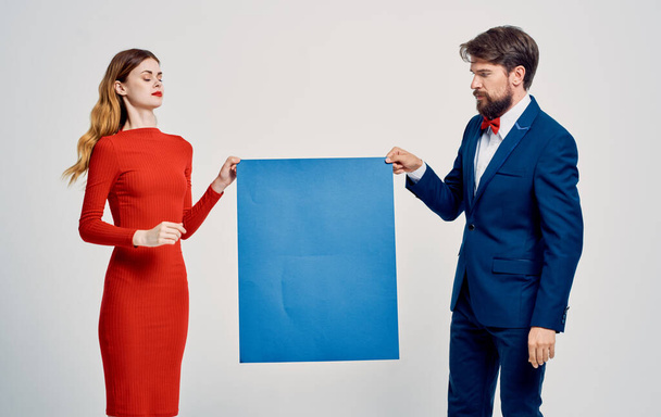 Άνδρας και γυναίκα με μπλε φύλλο χαρτιού σε ένα ελαφρύ φόντο περικοπεί άποψη - Φωτογραφία, εικόνα