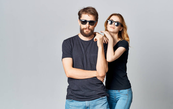 молодая пара в черных футболках солнцезащитные очки студийный романтический стиль общения - Фото, изображение