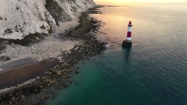 Tájkép légi drón felvétel videó egy Beachy Head világítótorony és kréta sziklák színes napkeltekor alacsony apály Angliában, közel Eastbourne - Felvétel, videó