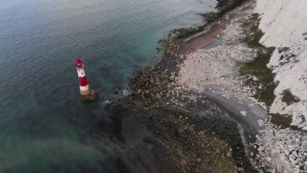Vidéo aérienne d'un phare de Beachy Head et de falaises de craie au lever du soleil coloré avec marée basse en Angleterre, près d'Eastbourne - Séquence, vidéo
