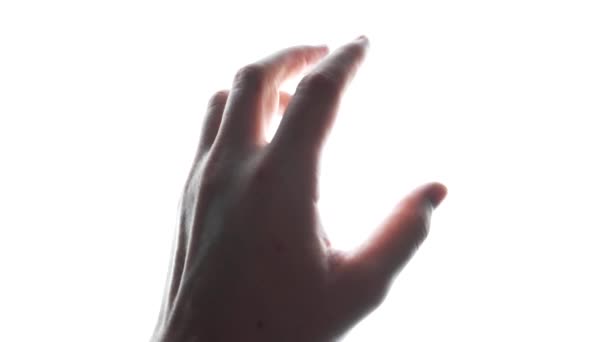 Gros plan de l'homme regardant sa main dans la lumière sur fond blanc - Séquence, vidéo