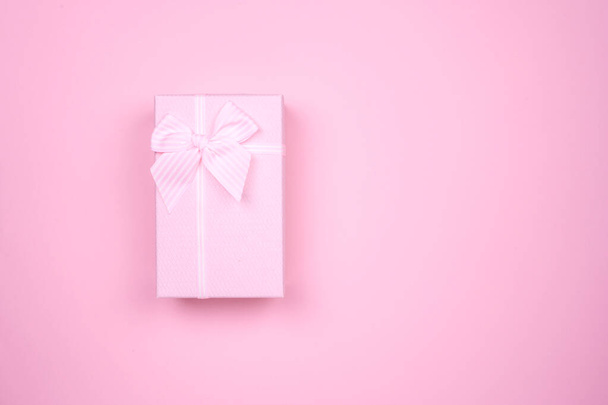 Gift rectangular pink box with bow on a pink background. - Foto, afbeelding