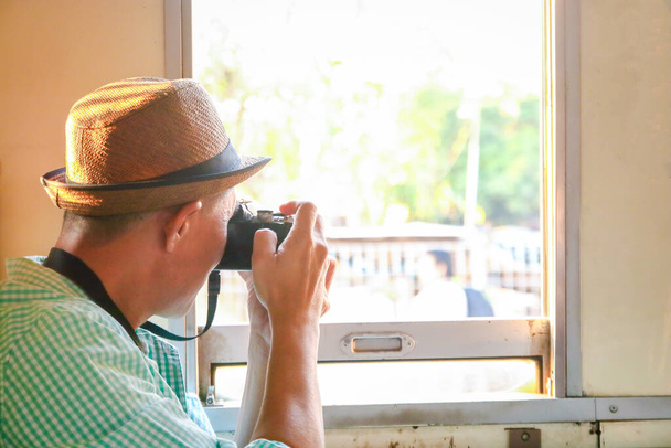 I turisti asiatici indossano cappelli verdi. Sedersi sul treno, tenere la macchina fotografica, scattare foto - Foto, immagini