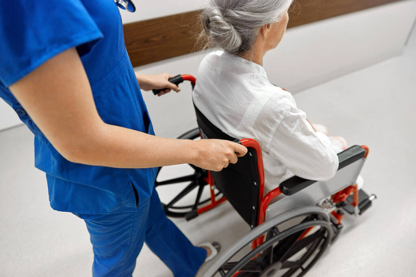 nurse with senior patient in wheelchair at clinic - Фото, зображення