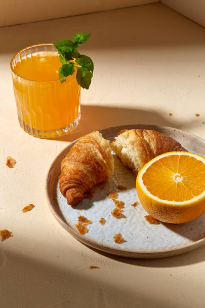 glass of orange juice and croissant on plate - Foto, Imagen