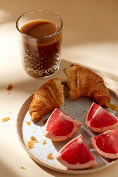 glass of coffee, croissant and grapefruit on table - Foto, immagini