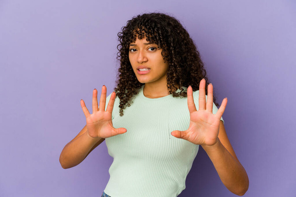 Giovane afro-americana afro donna isolata che rifiuta qualcuno mostrando un gesto di disgusto. - Foto, immagini