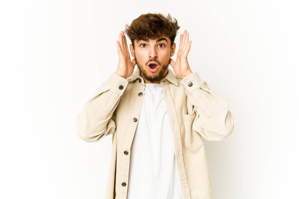 Young arab man on white background surprised and shocked. - Photo, Image