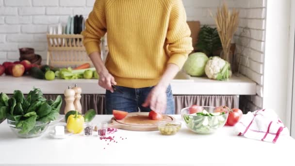 健康食品の製造。野菜サラダを作る女。トマトを切る女の手 - 映像、動画
