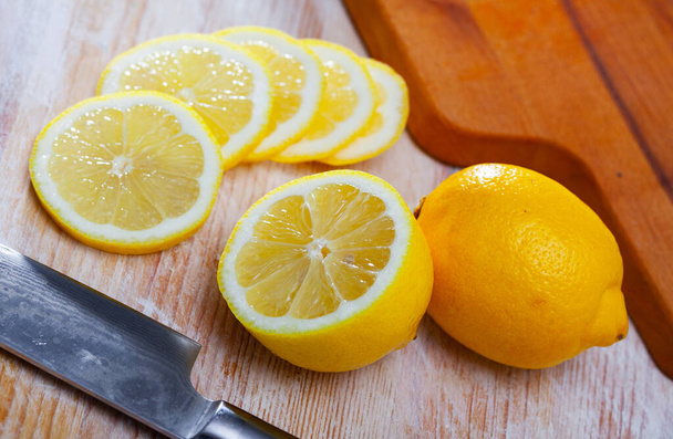 Lemon slices on wooden cutting board - Fotó, kép
