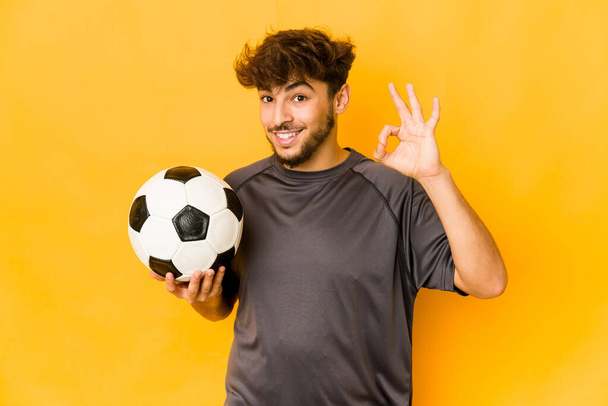 Jovem jogador de futebol índio homem alegre e confiante mostrando ok gesto. - Foto, Imagem