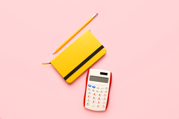 Digital calculator, notebook and pencil on color background - Фото, зображення