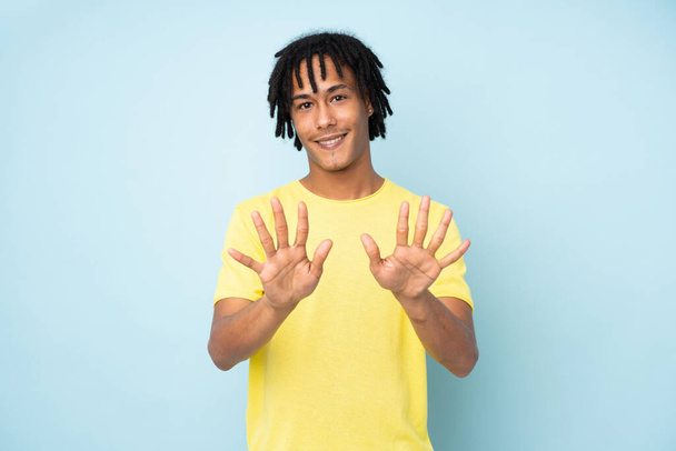 Junger afrikanisch-amerikanischer Mann isoliert auf blauem Hintergrund, der mit den Fingern zehn zählt - Foto, Bild