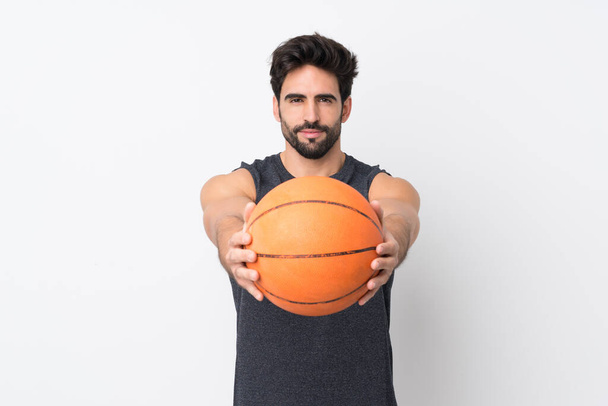 Jovem homem bonito com barba sobre fundo branco isolado jogando basquete - Foto, Imagem