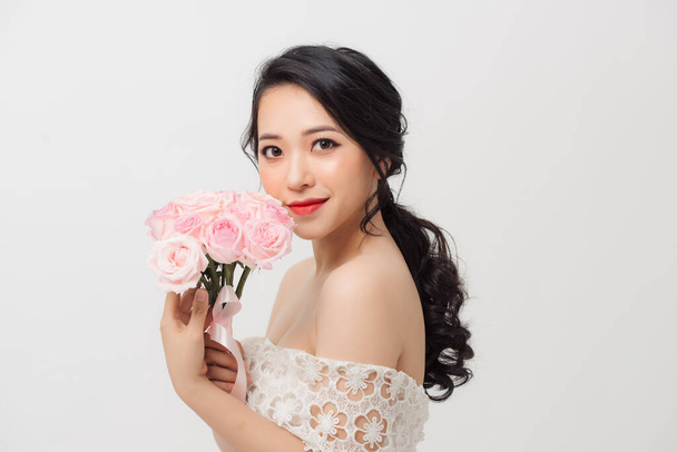 Portrait de femme élégante avec bouquet de fleurs sur fond blanc. - Photo, image